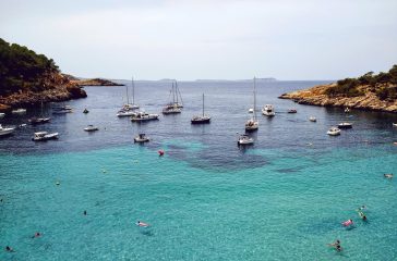 An aerial shot of the beach near Ibiza full od boats and people