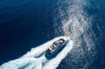An aerial shot of a yacht sailing on the sea at daytime