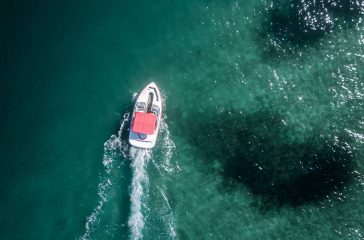 A little motorboat moving forward in the sea shot from above